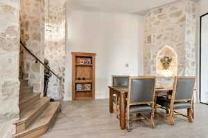 Dining room featuring a towering ceiling and light hardwood / wood-style floors