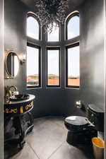 Bathroom with toilet, concrete flooring, and a wealth of natural light