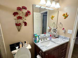 Bathroom with a textured ceiling, vanity, toilet, and a shower with shower door