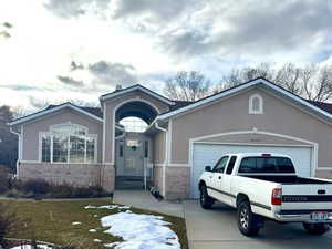 View of front of house featuring a garage and a yard