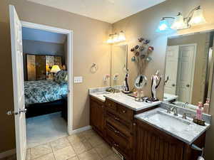 Bathroom with vanity, tile patterned flooring, and a textured ceiling