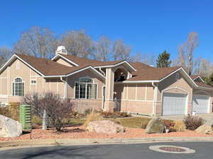 Ranch-style home with concrete driveway, roof with shingles, an attached garage, and stucco siding