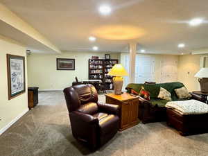 Living room featuring carpet flooring and a textured ceiling