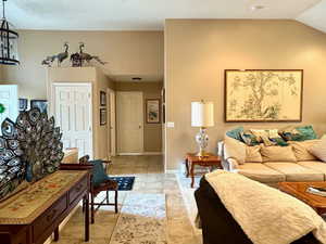 Living room with lofted ceiling and an inviting chandelier