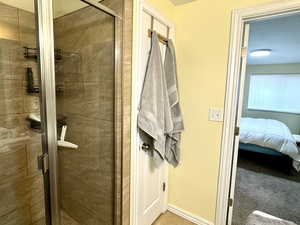 Bathroom with a textured ceiling, a shower with shower door, and tile patterned floors