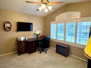 Office space featuring a textured ceiling, light carpet, lofted ceiling, and ceiling fan