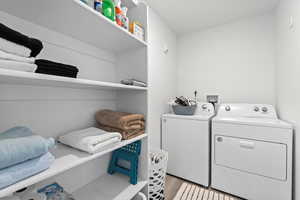 Laundry area featuring separate washer and dryer and light hardwood / wood-style flooring