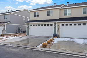 View of property with a garage and central air condition unit