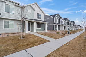 Townhome / multi-family property featuring a front lawn