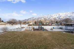 View of yard featuring a playground, a trampoline, and a mountain view