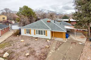 Ranch-style house with a mountain view, a carport, a garage, and an outbuilding