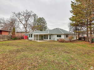 Rear view of property with a patio area and a lawn