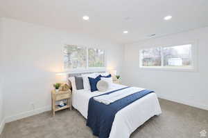 Carpeted bedroom featuring multiple windows