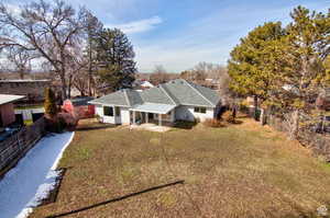 View of front of property featuring a patio, a storage unit, and a front lawn