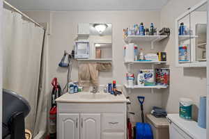 Bathroom with vanity, a shower with curtain, and toilet