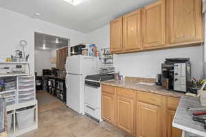 Kitchen featuring white appliances and a textured ceiling