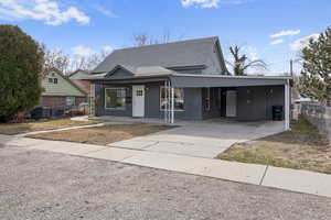 View of front of home with a porch and a carport