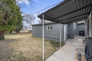 View of parking with a lawn and a carport