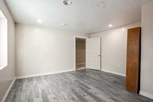 Unfurnished room featuring dark wood-type flooring and a textured ceiling