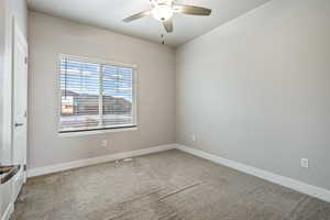 Spare room with ceiling fan and carpet floors