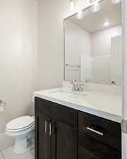 Bathroom with vanity, toilet, and tile patterned floors