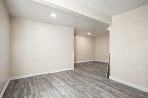 Basement with a textured ceiling and hardwood / wood-style flooring
