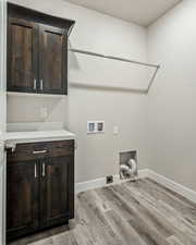 Laundry area with light hardwood / wood-style floors, washer hookup, cabinets, and hookup for an electric dryer