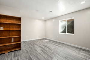 Unfurnished room featuring light wood-type flooring and a textured ceiling