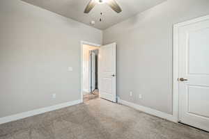 Unfurnished bedroom featuring ceiling fan and light carpet