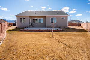 Rear view of property featuring a patio area and a lawn