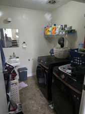 Unit 3 Clothes washing area featuring a textured ceiling, sink, and washer and clothes dryer