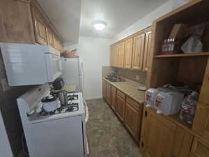 Unit 1 Kitchen with sink, white appliances, and decorative backsplash