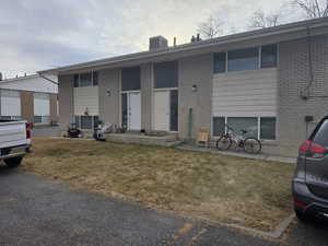 View of front of home featuring central AC and a front yard