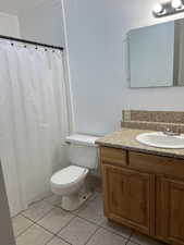 Unit 1 Bathroom featuring toilet, tile patterned flooring, and vanity