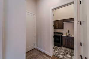 Hall with washer / dryer, sink, and light wood-type flooring