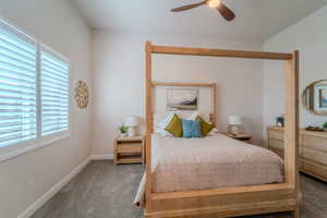 Carpeted bedroom featuring ceiling fan