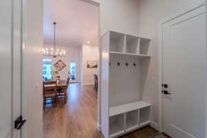 Mudroom featuring a chandelier and wood-type flooring