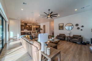 Living room with light wood-type flooring and ceiling fan