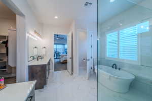 Bathroom featuring vanity, a washtub, and ceiling fan