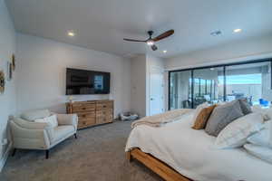 Carpeted bedroom featuring ceiling fan and access to exterior