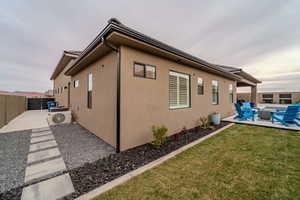 View of property exterior with ac unit, a yard, a fire pit, and a patio area