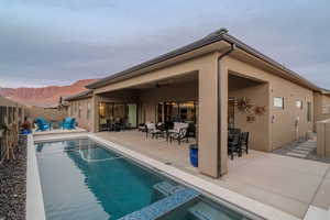 Back of house featuring a mountain view, a pool with hot tub, ceiling fan, and a patio area