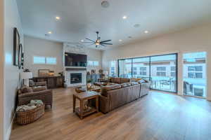 Living room featuring a fireplace, light hardwood / wood-style flooring, and ceiling fan