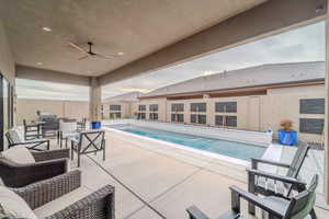 View of pool with ceiling fan and a patio area