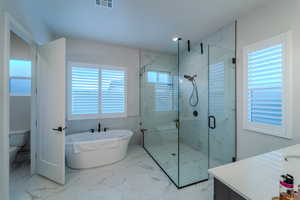 Full bathroom with separate shower and tub, vanity, and toilet