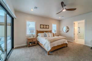 Bedroom with connected bathroom, ceiling fan, access to outside, and light colored carpet