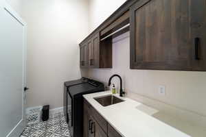 Laundry area featuring cabinets, sink, and independent washer and dryer