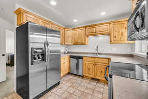 Kitchen featuring appliances with stainless steel finishes, sink, and oak cabinetry