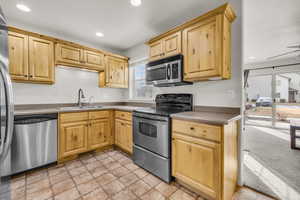 Kitchen featuring sink, appliances with stainless steel finishes and oak cabinetry