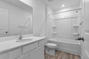 Full bathroom featuring toilet, vanity, shower / bathtub combination, and wood-type flooring